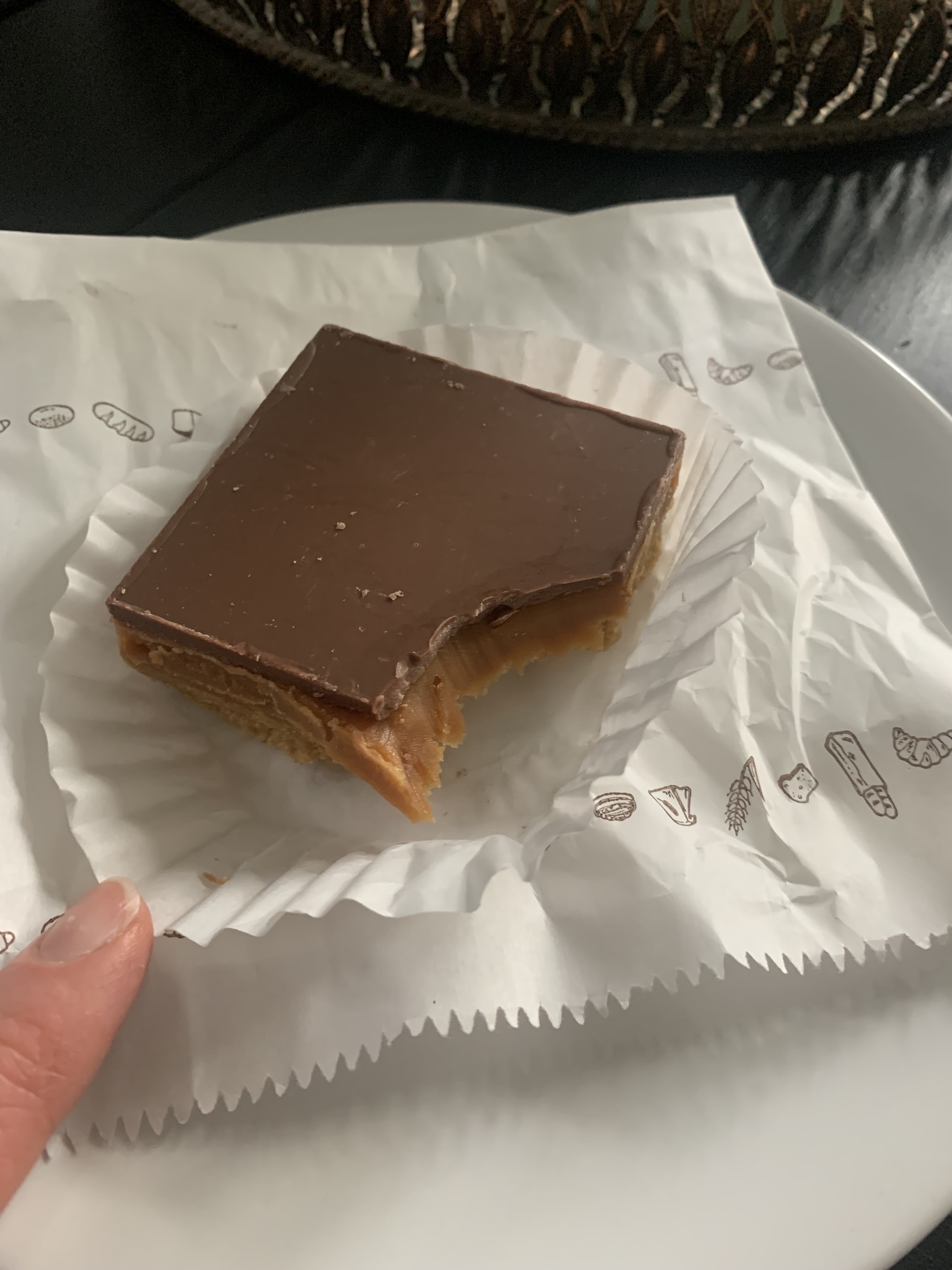 A chocolate-topped bakery slice on paper